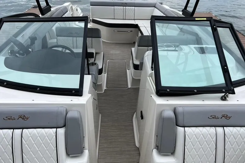 Slide: The Image of 2016 Sea Ray 270 Sundeck interior with seating and windshield, docked by the water. - 3