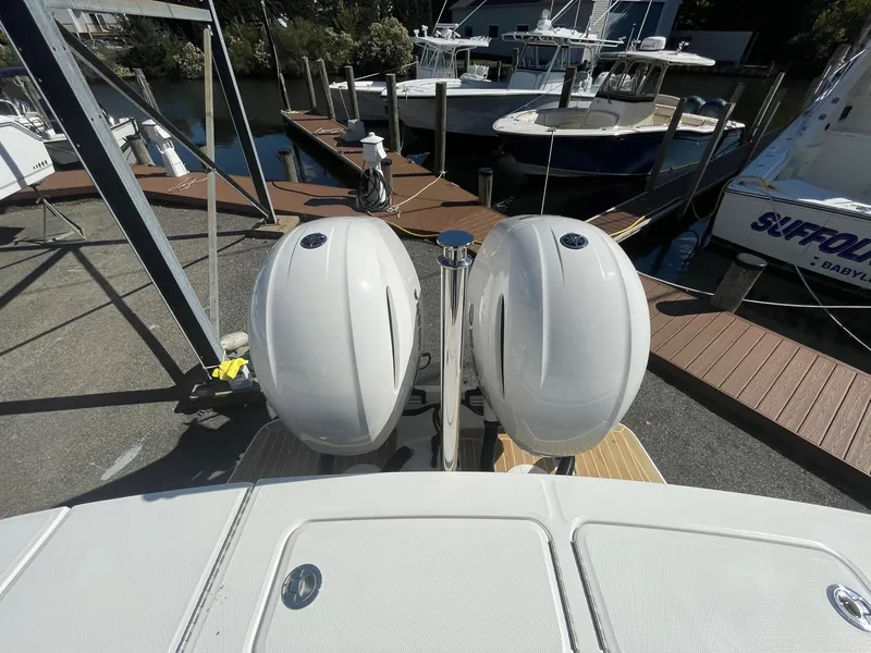Slide: The Image of 2019 Regulator 23 boat with dual outboard engines at a marina dock. - 18