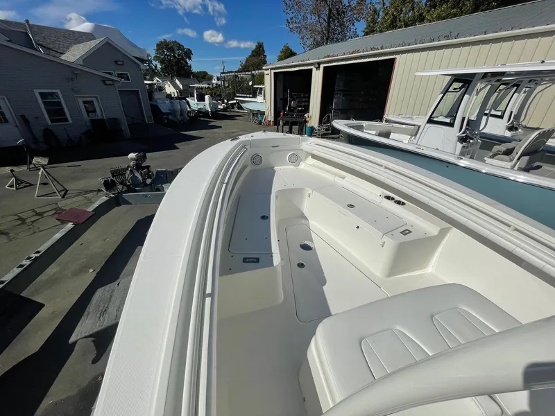Slide: The Image of 2019 Regulator 23 boat with spacious seating, docked near garages under a clear blue sky. - 19