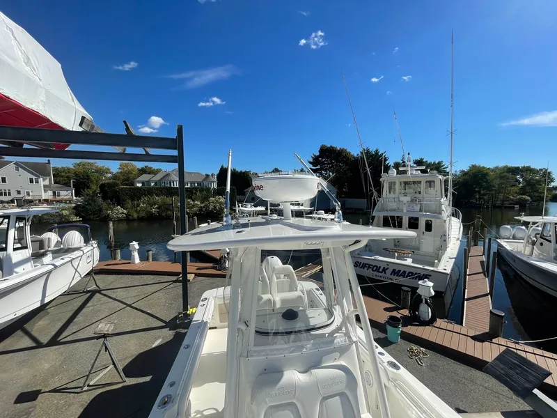 Slide: The Image of 2019 Regulator 23 boat docked at marina under clear blue sky. - 22