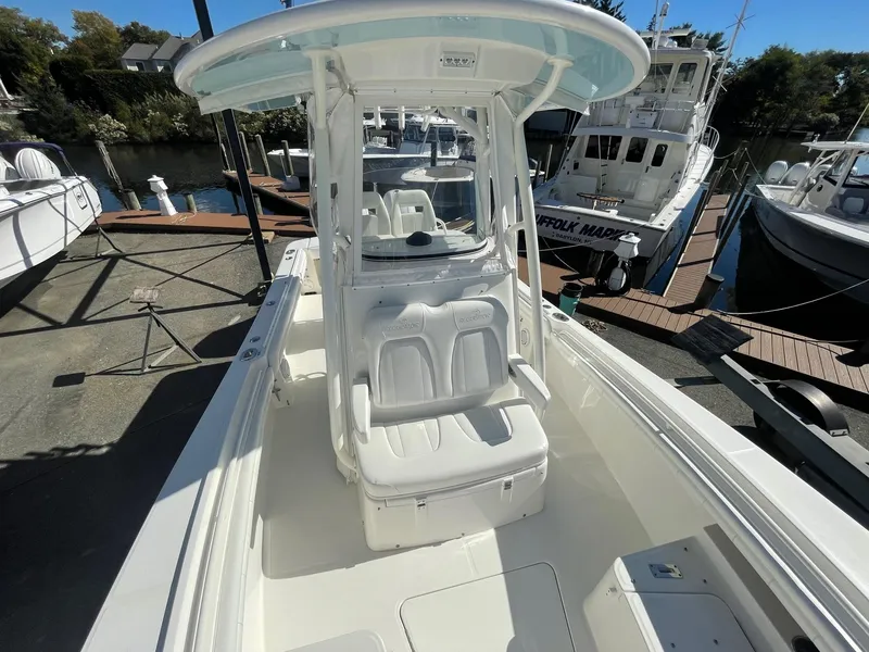 Slide: The Image of 2019 Regulator 23 boat with T-top, docked at marina, clear sunny day. - 23