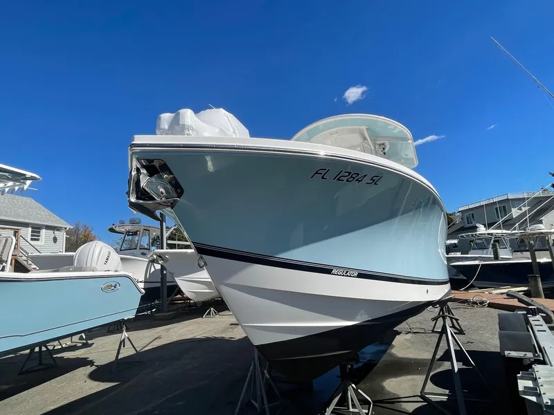 Slide: The Image of 2019 Regulator 23 boat on stands under clear blue sky. - 4