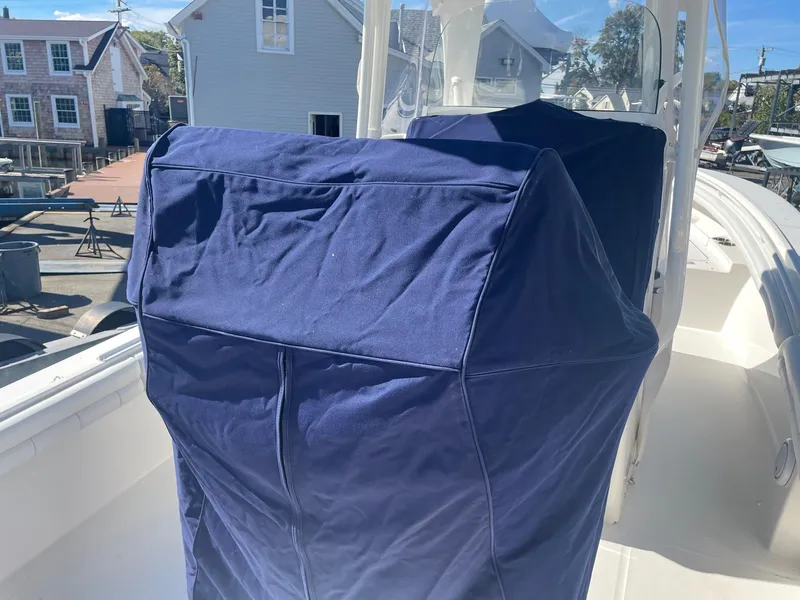 Slide: The Image of 2019 Regulator 23 boat with blue console covers, docked in a marina. - 41