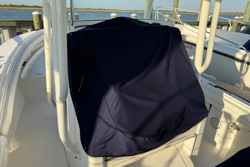 Slide: The Image of 2019 Regulator 23 boat with covered console, docked by the water. - 45