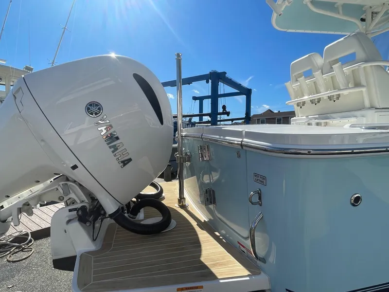 Slide: The Image of 2019 Regulator 23 boat with Yamaha outboard motor, docked under clear blue sky. - 6