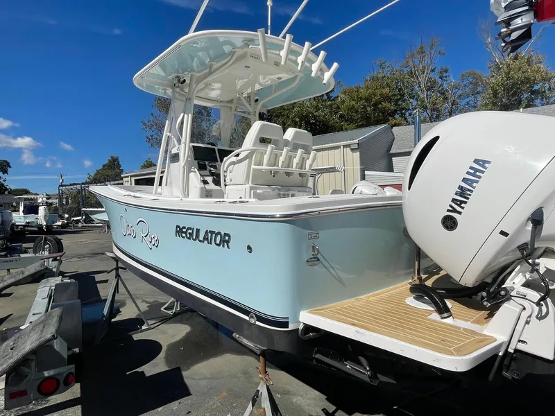 Slide: The Image of 2019 Regulator 23 boat with Yamaha engine, docked outdoors under clear blue sky. - 7