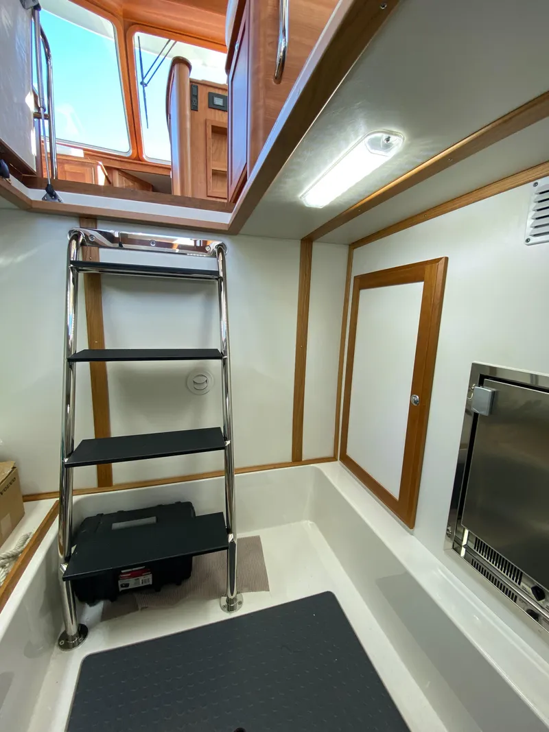 Slide: The Image of 2019 Sabre 45 Salon Express cabin with nautical-themed bedding and wooden interior. - 46