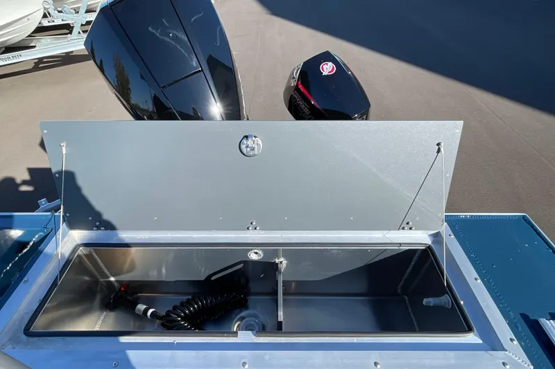 Slide: The Image of Open storage compartment on 2026 Hewescraft 210 Sea Runner ET boat, with visible engine. - 10