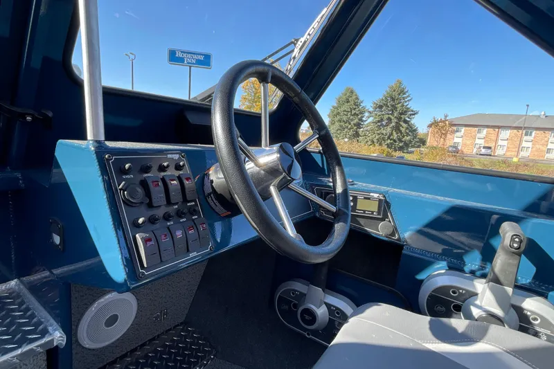 Slide: The Image of Interior of 2026 Hewescraft 210 Sea Runner ET boat, featuring steering wheel and control panel. - 23