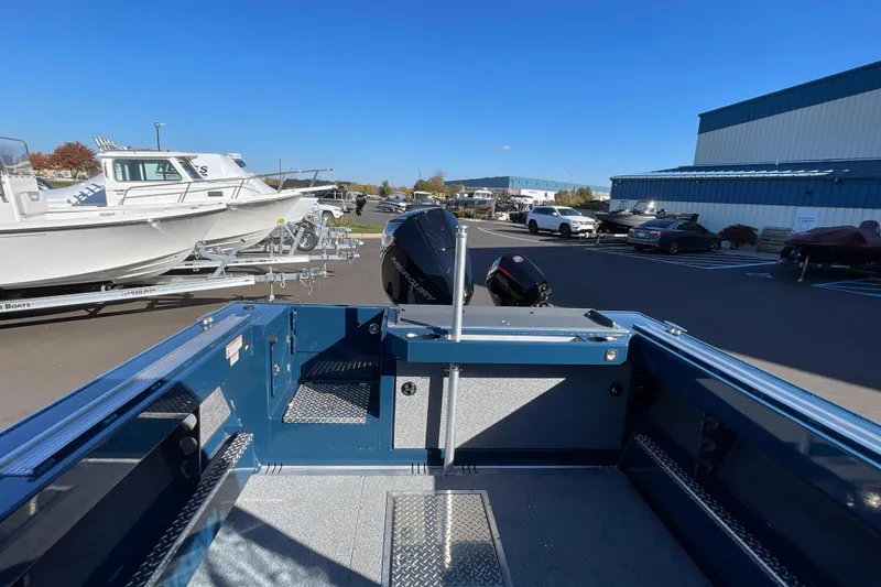Slide: The Image of 2026 Hewescraft 210 Sea Runner ET boat in a dealership lot under clear blue sky. - 30