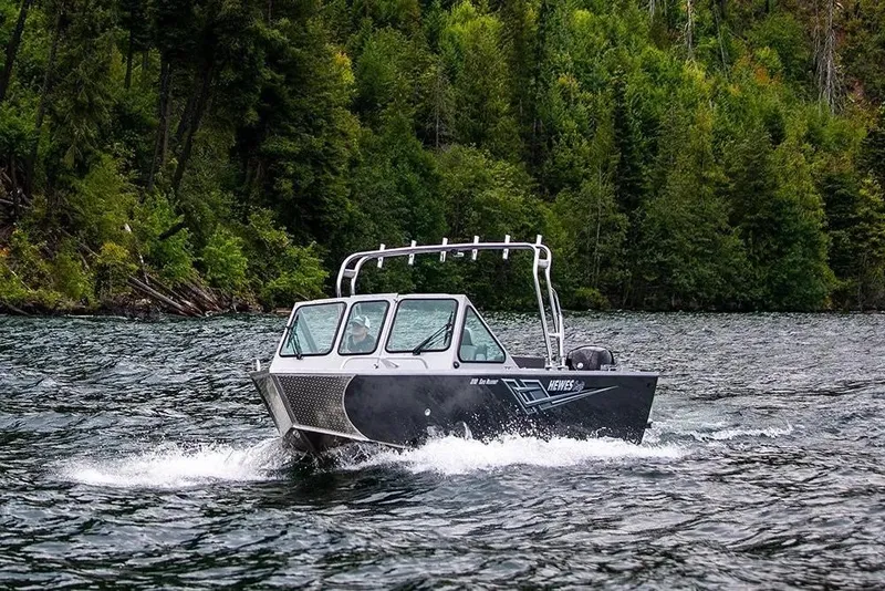 Slide: The Image of 2026 Hewescraft 210 Sea Runner ET navigating a scenic, forested lake. - 33