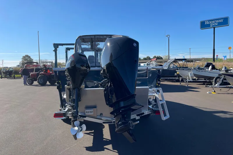 Slide: The Image of 2026 Hewescraft 210 Sea Runner ET boat with dual outboard motors in a parking lot. - 5