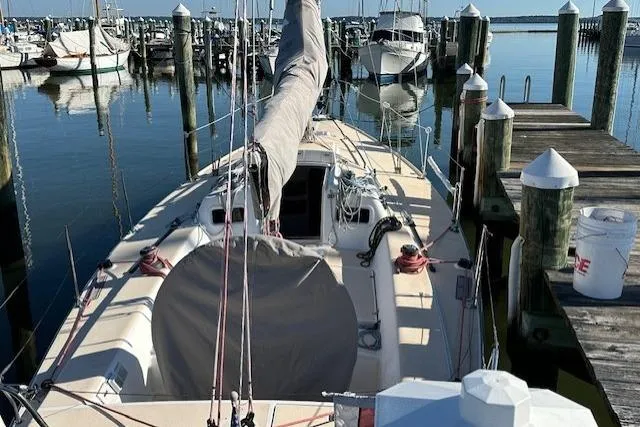 Slide: The Image of 2002 J Boats J/105 sailboat docked at a marina, surrounded by calm water. - 4