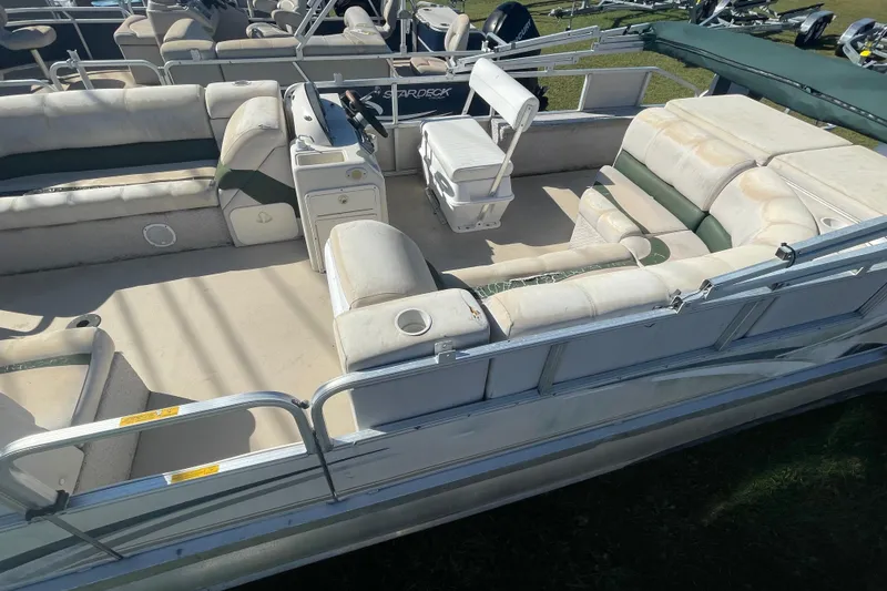Slide: The Image of 2005 Avalon Paradise RF22 pontoon boat with spacious seating and helm, parked on grass. - 3