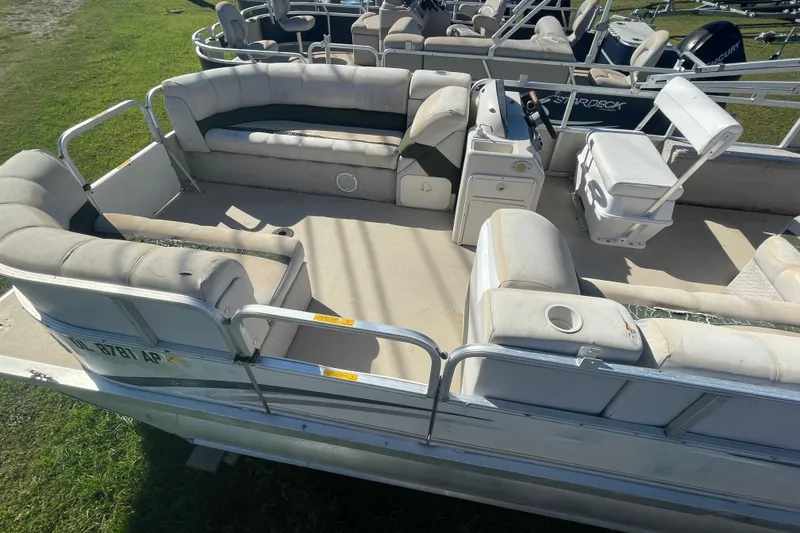 Slide: The Image of 2005 Avalon Paradise RF22 pontoon boat with spacious seating and helm, parked on grass. - 4