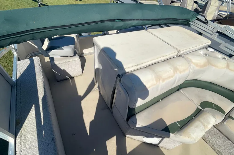 Slide: The Image of 2005 Avalon Paradise RF22 boat interior with worn seating and green canopy. - 6