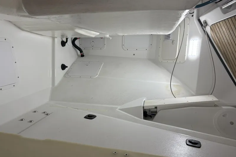 Slide: The Image of Interior view of a 2012 Jeanneau 57 sailboat, showcasing clean, white storage compartments. - 11