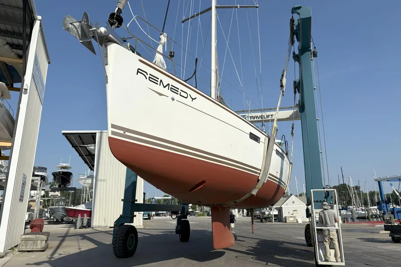 Slide: The Image of 2012 Jeanneau 57 sailboat "Remedy" lifted in a marina with blue sky background. - 2