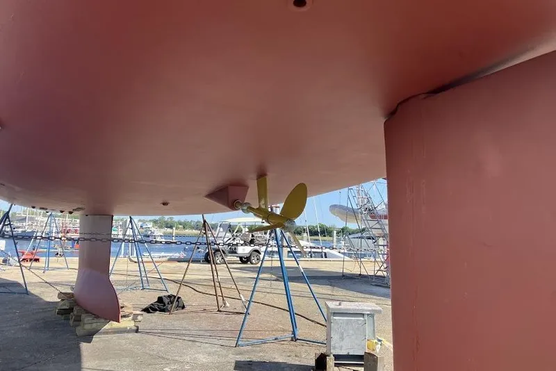 Slide: The Image of Underneath view of a 2012 Jeanneau 57 yacht on dry dock, showcasing the propeller and keel. - 3