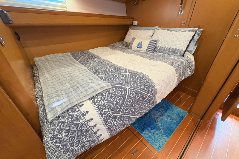 Slide: The Image of Cozy cabin bedroom in a 2012 Jeanneau 57 yacht with nautical-themed bedding. - 37