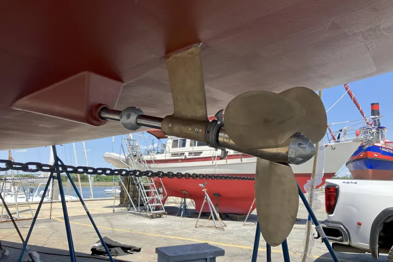 Slide: The Image of Propeller of 2012 Jeanneau 57 sailboat in dry dock, with other boats in background. - 4
