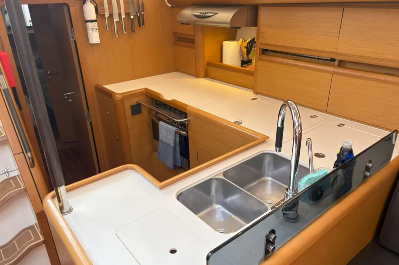 Slide: The Image of Modern kitchen in a 2012 Jeanneau 57 yacht with dual sinks and wooden cabinetry. - 47