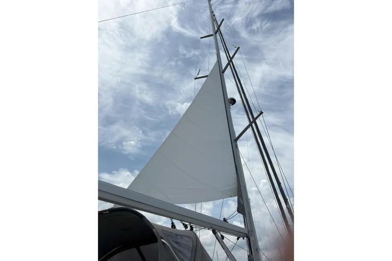 Slide: The Image of Sail of a 2012 Jeanneau 57 yacht against a cloudy sky. - 5