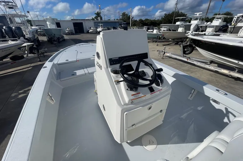 Slide: The Image of 2026 Pathfinder 2500 Hybrid boat interior with steering console, docked among other boats. - 9