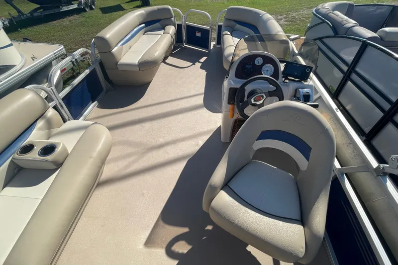 Slide: The Image of 2013 Sun Tracker Party Barge 18 DLX interior with beige seating and steering console. - 12