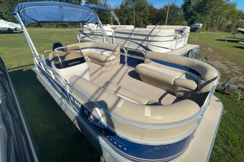 Slide: The Image of 2013 SUNTRACKER Party Barge 18 DLX pontoon boat with beige seating and blue accents. - 3
