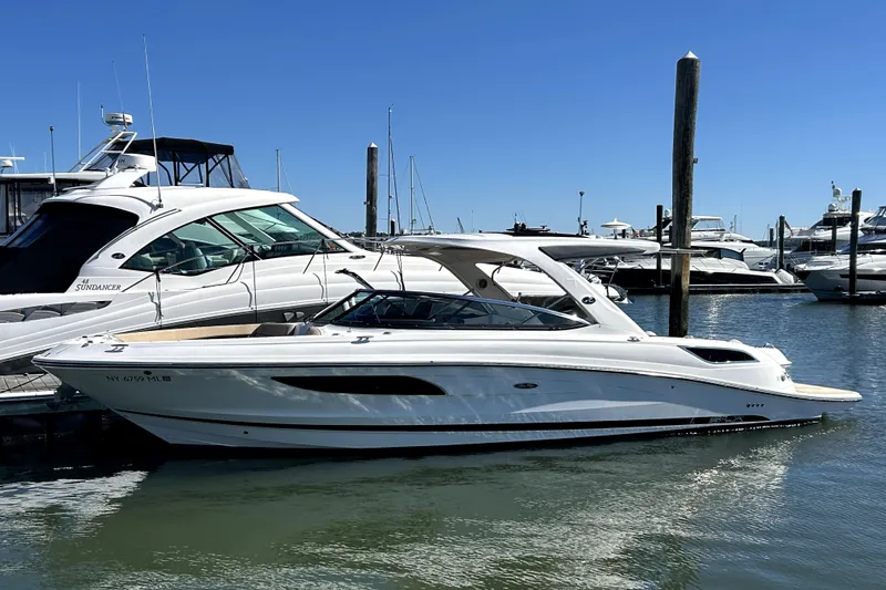 The Image of 2016 Sea Ray 350 SLX boat docked in marina under clear blue sky. - 0