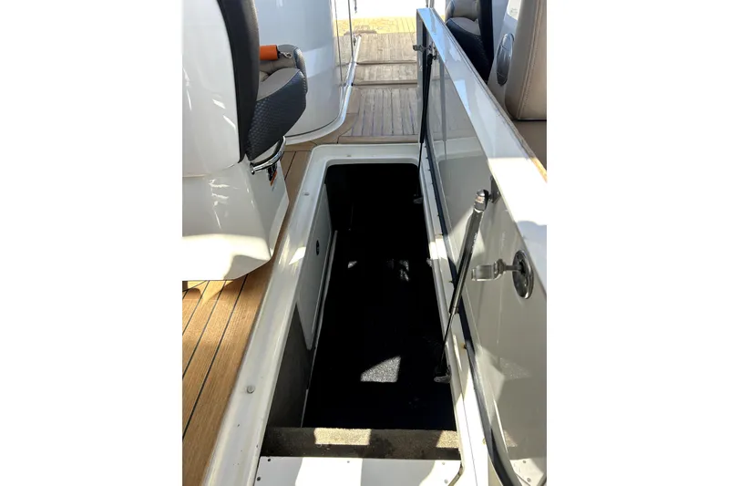 Slide: The Image of 2016 Sea Ray 350 SLX boat interior with open storage compartment and seating. - 9