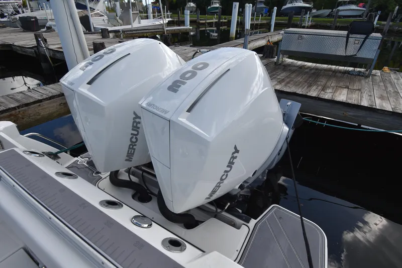 Slide: The Image of Twin Mercury outboard engines on a 2022 Blackfin 272DC boat at a dock. - 11