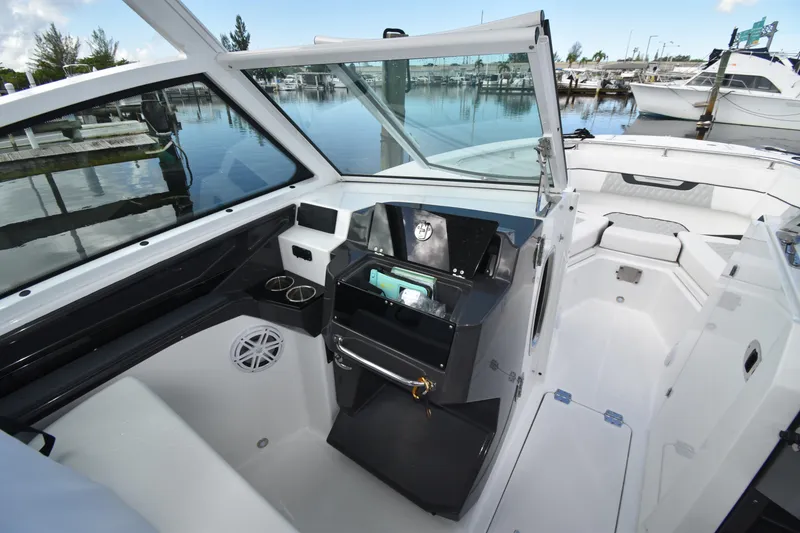 Slide: The Image of 2022 Blackfin 272DC boat interior with seating and storage, docked at marina. - 13