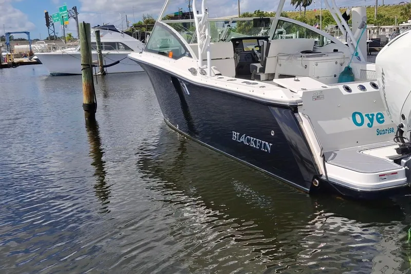 Slide: The Image of 2023 Blackfin 272DC boat docked in marina, featuring sleek design and modern amenities. - 17