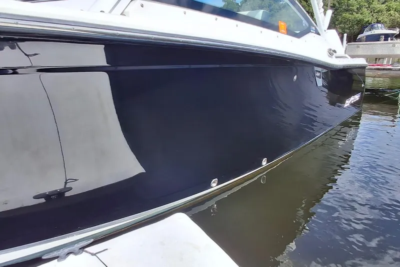 Slide: The Image of 2023 Blackfin 272DC boat side view on water, reflecting surroundings. - 18