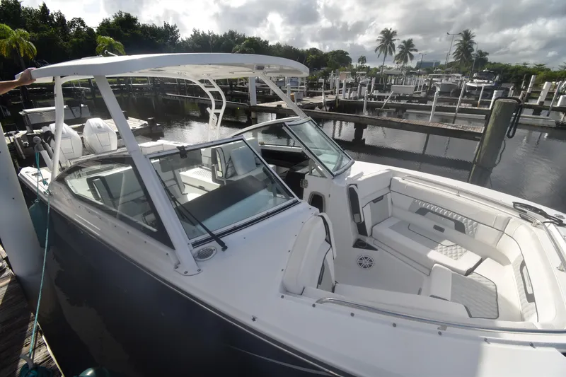 Slide: The Image of 2022 Blackfin 272DC boat docked, featuring sleek design and spacious seating. - 22