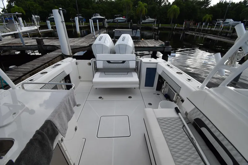 Slide: The Image of 2022 Blackfin 272DC boat interior with dual engines at a marina dock. - 25