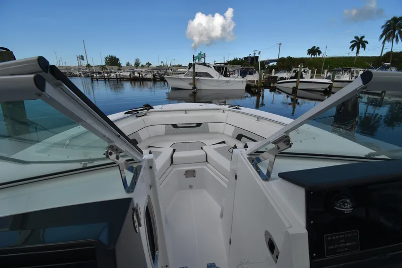 Slide: The Image of 2022 Blackfin 272DC boat docked in a marina with clear skies and palm trees. - 28