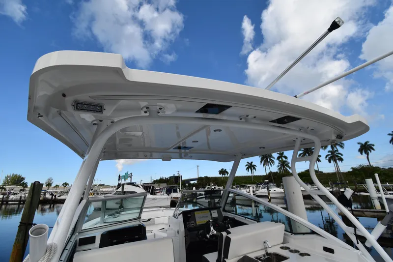 Slide: The Image of 2022 Blackfin 272DC boat with hardtop, docked under a blue sky with palm trees. - 30