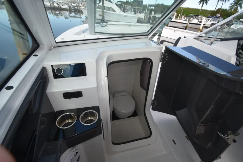 Slide: The Image of 2022 Blackfin 272DC boat interior with compact marine toilet and cup holders. - 8