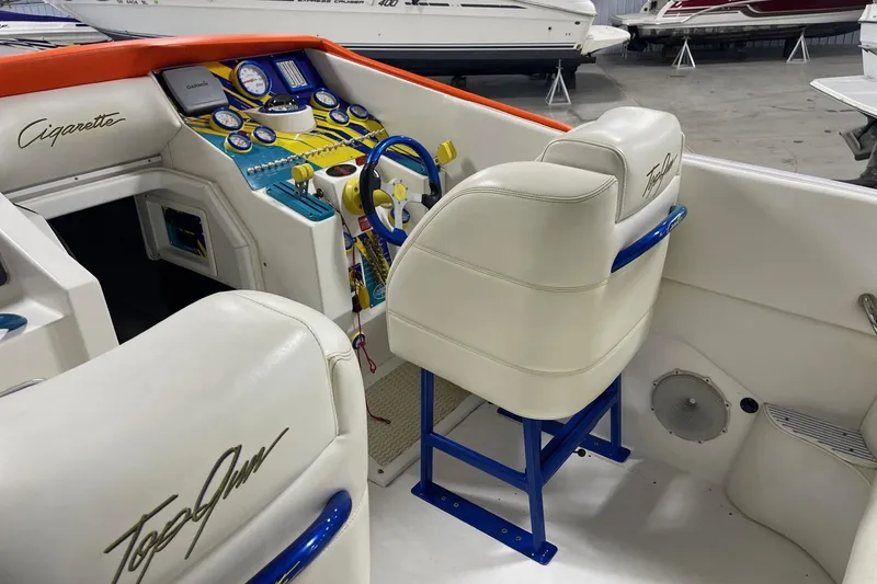 Slide: The Image of 2002 Cigarette 38 Top Gun boat interior with white seats and colorful dashboard. - 18