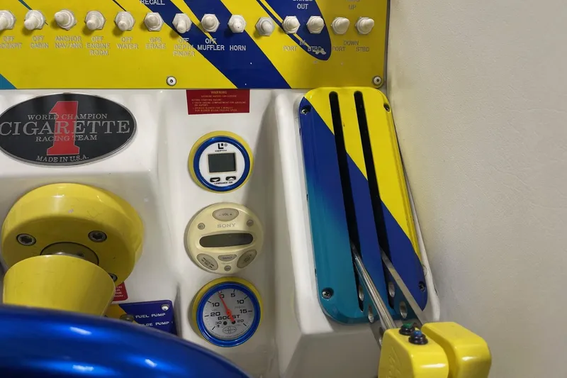 Slide: The Image of Control panel of a 2002 Cigarette 38 Top Gun boat with vibrant yellow and blue accents. - 36