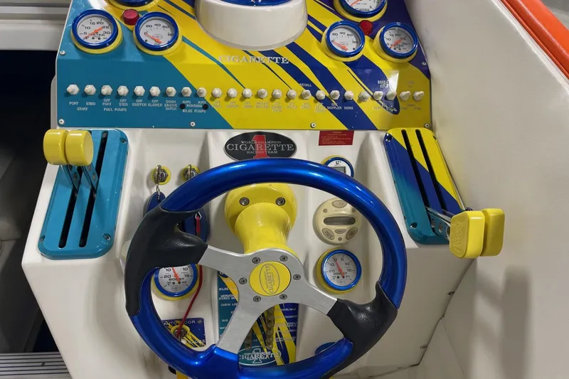 Slide: The Image of 2002 Cigarette 38 Top Gun boat dashboard with vibrant gauges and controls. - 38