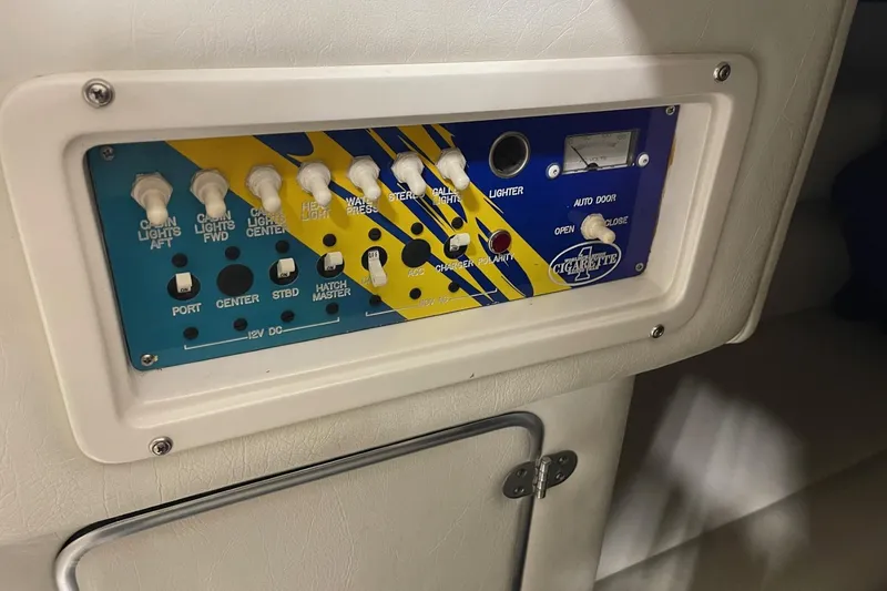 Slide: The Image of Control panel of a 2002 Cigarette 38 Top Gun boat with various switches and indicators. - 41