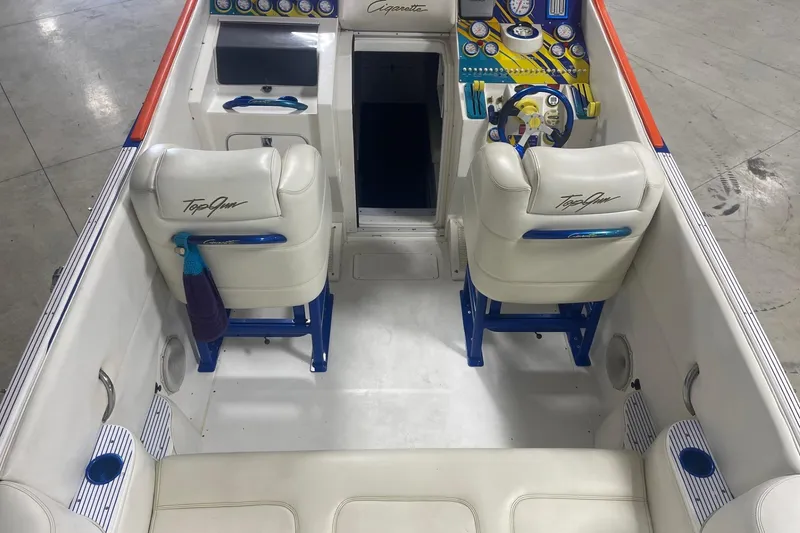 Slide: The Image of Interior of a 2002 Cigarette 38 Top Gun boat with white seating and colorful dashboard. - 9