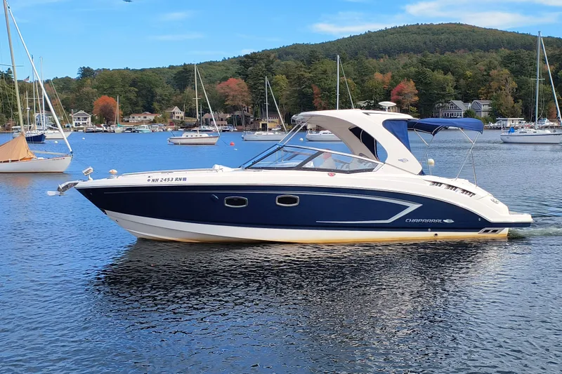 The Image of 2012 Chaparral 327 SSX boat on a scenic lake with sailboats and autumn trees. - 0