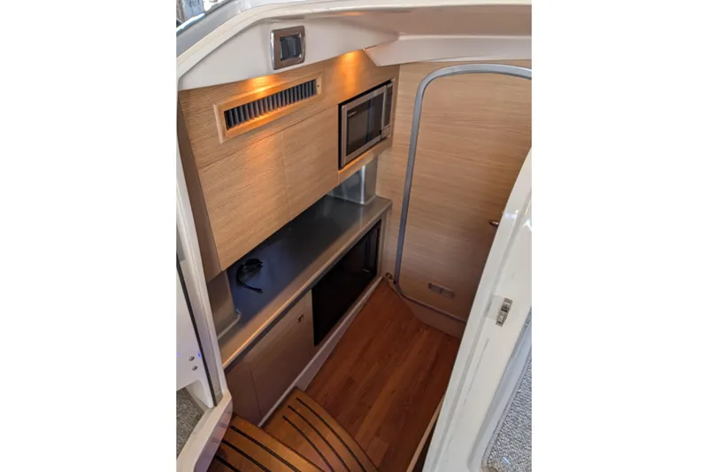 Slide: The Image of Interior of 2012 Chaparral 327 SSX boat with wood finish and modern amenities. - 16