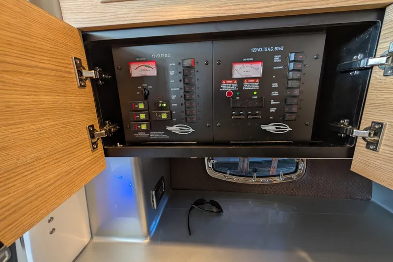 Slide: The Image of Electrical control panel inside 2012 Chaparral 327 SSX boat, featuring switches and meters. - 18