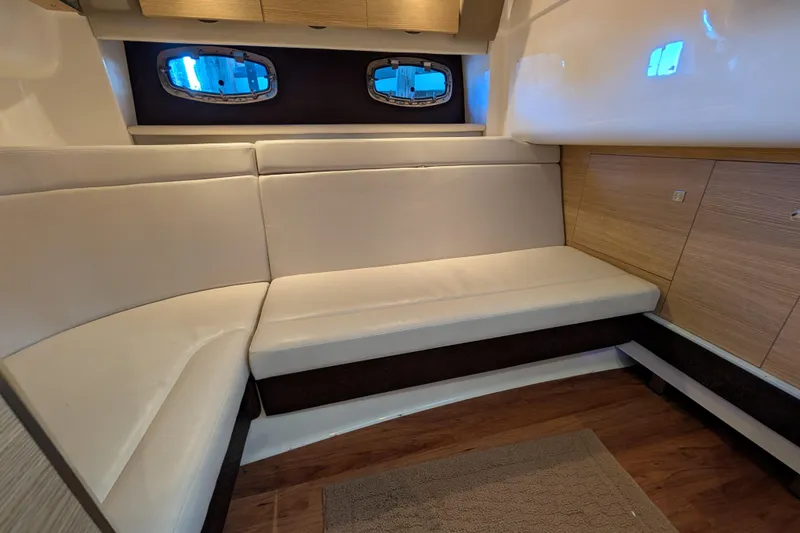 Slide: The Image of Interior of 2012 Chaparral 327 SSX boat with white leather seating and wooden accents. - 21